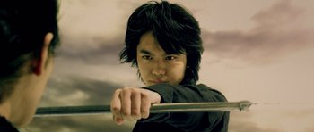 Movie still from “Goemon” (2009), directed by Kazuaki Kiriya – A young man holding onto a metal pole; Close Up shot, Low angle