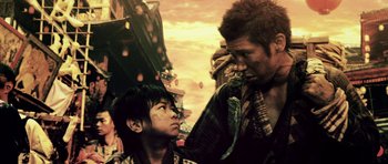 Movie still from “Goemon” (2009), directed by Kazuaki Kiriya – A man and a boy standing next to each other on a bridge; Medium shot, Low angle