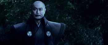 Movie still from “Goemon” (2009), directed by Kazuaki Kiriya – An older man wearing a black robe and a black jacket; Close Up shot, Low angle