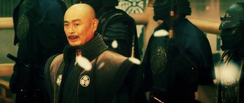Movie still from “Goemon” (2009), directed by Kazuaki Kiriya – A man with a bald head wearing a black jacket; Close Up shot, Over the shoulder angle