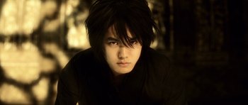 Movie still from “Goemon” (2009), directed by Kazuaki Kiriya – A man with long black hair is staring straight ahead; Close Up shot, Low angle