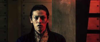 Movie still from “Goemon” (2009), directed by Kazuaki Kiriya – A man with long black hair wearing a black jacket; Close Up shot, Low angle