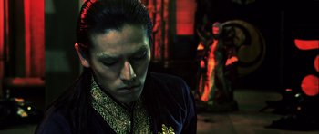 Movie still from “Goemon” (2009), directed by Kazuaki Kiriya – A man in a black and gold jacket looking down at his face; Close Up shot, Low angle