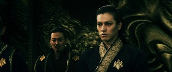 Movie still from “Goemon” (2009), directed by Kazuaki Kiriya – A man and a man in a black and gold outfit; Medium shot, Low angle