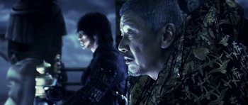 Movie still from “Goemon” (2009), directed by Kazuaki Kiriya – A man in a military jacket and another man in a dark room; Close Up shot, Low angle