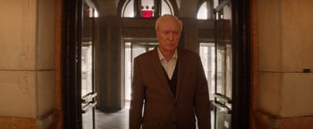 Movie still from “Going in Style” (2017), directed by Zach Braff – An older man wearing a suit and tie in an elevator; Medium shot, Low angle