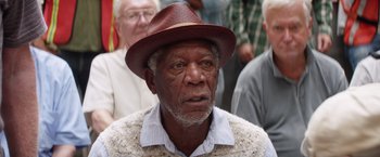 Movie still from “Going in Style” (2017), directed by Zach Braff – An older man wearing a brown hat and a white shirt; Close Up shot, Over the shoulder angle