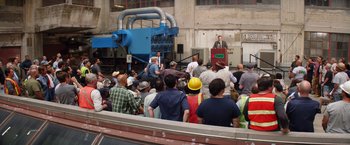 Movie still from “Going in Style” (2017), directed by Zach Braff – A group of people standing in front of a building; Wide shot, High angle