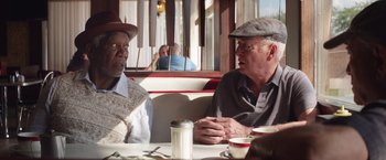 Movie still from “Going in Style” (2017), directed by Zach Braff – Two older men sitting at a table in a restaurant; Medium shot, Over the shoulder angle