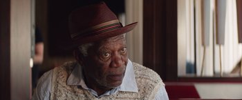Movie still from “Going in Style” (2017), directed by Zach Braff – An older man wearing a hat and a sweater; Close Up shot, Over the shoulder angle