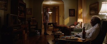 Movie still from “Going in Style” (2017), directed by Zach Braff – An older man standing in a living room next to an older man; Wide shot, Low angle