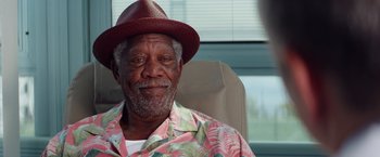 Movie still from “Going in Style” (2017), directed by Zach Braff – An older man wearing a red hat and a floral shirt; Close Up shot, Over the shoulder angle