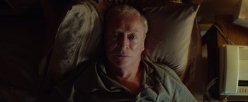 Movie still from “Going in Style” (2017), directed by Zach Braff – An older man laying in a bed with pillows; Close Up shot, Overhead angle