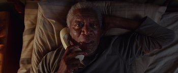 Movie still from “Going in Style” (2017), directed by Zach Braff – An older man talking on a phone while laying in bed; Close Up shot, Overhead angle