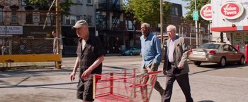 Movie still from “Going in Style” (2017), directed by Zach Braff – Three older men walking down the street with a shopping cart; Wide shot, Low angle