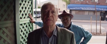 Movie still from “Going in Style” (2017), directed by Zach Braff – Two older men standing next to each other on the street; Medium shot, Low angle