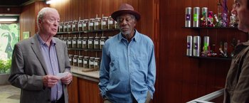 Movie still from “Going in Style” (2017), directed by Zach Braff – An older man wearing a blue shirt and a red hat; Medium shot, Low angle