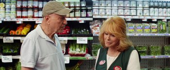 Movie still from “Going in Style” (2017), directed by Zach Braff – An older man and a woman talking in a store; Medium shot, Over the shoulder angle