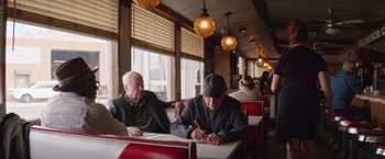 Movie still from “Going in Style” (2017), directed by Zach Braff – Two older men sitting at a table in a restaurant; Medium shot, Low angle