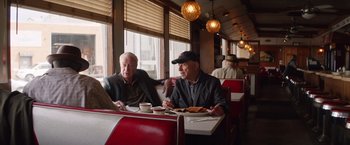 Movie still from “Going in Style” (2017), directed by Zach Braff – Two older men sitting at a table in a restaurant; Medium shot, Low angle