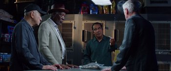 Movie still from “Going in Style” (2017), directed by Zach Braff – A man smoking a cigarette in front of two other men; Medium shot, Over the shoulder angle