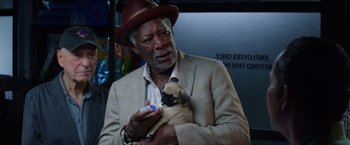 Movie still from “Going in Style” (2017), directed by Zach Braff – An older man holding a small pug puppy; Close Up shot, Over the shoulder angle