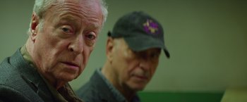 Movie still from “Going in Style” (2017), directed by Zach Braff – Two older men standing next to each other in a room; Close Up shot, Over the shoulder angle
