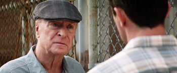 Movie still from “Going in Style” (2017), directed by Zach Braff – An older man wearing a hat talking to a younger man; Close Up shot, Over the shoulder angle