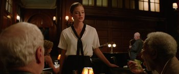 Movie still from “Going in Style” (2017), directed by Zach Braff – A woman standing in front of a table with a lamp; Medium shot, Over the shoulder angle