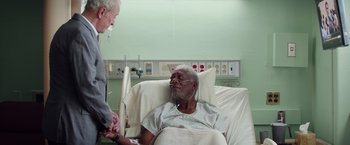 Movie still from “Going in Style” (2017), directed by Zach Braff – An older man in a hospital bed talking to a doctor; Medium shot, Over the shoulder angle
