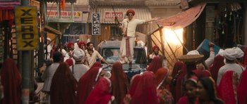 Movie still from “Goliyon Ki Raasleela Ram Leela” (2013), directed by Sanjay Leela Bhansali – A man standing on the hood of a car in front of a group of people; Wide shot, Low angle