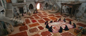 Movie still from “Goliyon Ki Raasleela Ram Leela” (2013), directed by Sanjay Leela Bhansali – A group of people sitting around a room filled with lots of food; Extreme Wide shot, Overhead angle