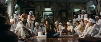 Movie still from “Goliyon Ki Raasleela Ram Leela” (2013), directed by Sanjay Leela Bhansali – A group of men sitting on the floor of a room; Wide shot, Low angle