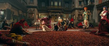Movie still from “Goliyon Ki Raasleela Ram Leela” (2013), directed by Sanjay Leela Bhansali – A group of people sitting on the ground in front of a building; Wide shot, High angle
