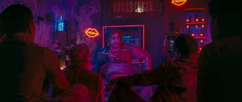 Movie still from “Goliyon Ki Raasleela Ram Leela” (2013), directed by Sanjay Leela Bhansali – A man sitting at a table in front of neon lights; Medium shot, Over the shoulder angle