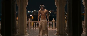 Movie still from “Goliyon Ki Raasleela Ram Leela” (2013), directed by Sanjay Leela Bhansali – A shirtless man standing in front of a railing at night; Medium shot, Low angle