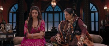 Movie still from “Goliyon Ki Raasleela Ram Leela” (2013), directed by Sanjay Leela Bhansali – Two women sitting at a table in front of a window; Medium shot, Over the shoulder angle