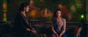 Movie still from “Goliyon Ki Raasleela Ram Leela” (2013), directed by Sanjay Leela Bhansali – Two women sitting in front of a painting of a woman; Medium shot, Over the shoulder angle