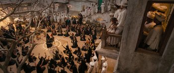 Movie still from “Goliyon Ki Raasleela Ram Leela” (2013), directed by Sanjay Leela Bhansali – A group of people sitting on the ground in front of statues; Extreme Wide shot, High angle