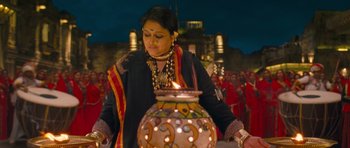 Movie still from “Goliyon Ki Raasleela Ram Leela” (2013), directed by Sanjay Leela Bhansali – A woman lighting a candle in front of an urn; Medium shot, Low angle