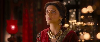 Movie still from “Goliyon Ki Raasleela Ram Leela” (2013), directed by Sanjay Leela Bhansali – Deepika padukone in a red outfit with gold jewelry; Close Up shot, Over the shoulder angle