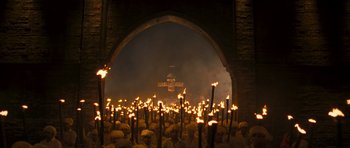 Movie still from “Goliyon Ki Raasleela Ram Leela” (2013), directed by Sanjay Leela Bhansali – A group of people standing around lit up torches in front of an archway; Extreme Wide shot, High angle