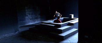 Movie still from “Gomorrah” (2008), directed by Matteo Garrone – Two men sitting on steps looking at each other; Extreme Wide shot, High angle