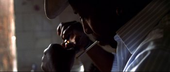 Movie still from “Gomorrah” (2008), directed by Matteo Garrone – A man smoking a cigarette while looking at a cell phone; Close Up shot, Low angle