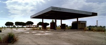 Movie still from “Gomorrah” (2008), directed by Matteo Garrone – An empty gas station sits in the middle of nowhere; Extreme Wide shot, Low angle