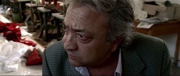 Movie still from “Gomorrah” (2008), directed by Matteo Garrone – An older man with grey curly hair looking to his left; Close Up shot, Low angle