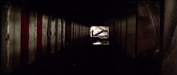 Movie still from “Gomorrah” (2008), directed by Matteo Garrone – A person standing in a dark room with a reflection in the water; Extreme Wide shot, High angle
