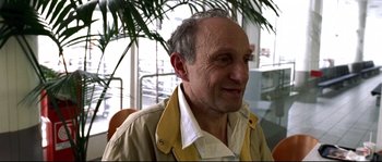 Movie still from “Gomorrah” (2008), directed by Matteo Garrone – An older man wearing a yellow jacket and a white shirt; Close Up shot, Over the shoulder angle
