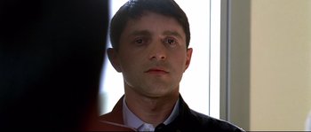 Movie still from “Gomorrah” (2008), directed by Matteo Garrone – A person wearing a suit and tie; Close Up shot, Low angle