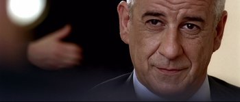 Movie still from “Gomorrah” (2008), directed by Matteo Garrone – A person wearing a suit and tie; Close Up shot, Low angle